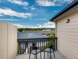 A balcony with two chairs and a view at Napier Holiday Home in Napier