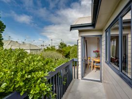A balcony overlooking a garden area at Napier Holiday Home in Napier