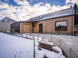 A house with a wooden facade and snow at Cedarwood Retreat - Castle Hill