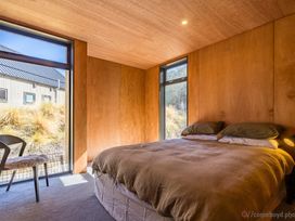 A bedroom with a bed and chair at Cedarwood Retreat - Castle Hill