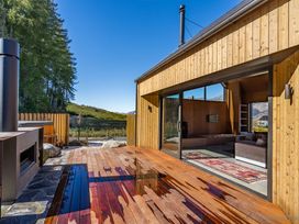A deck area with furniture and glass doors at Cedarwood Retreat - Castle Hill