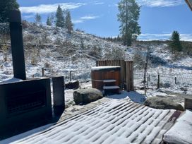 An outdoor area with a hot tub and fireplace at Cedarwood Retreat - Castle Hill