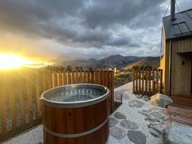 An outdoor space with a hot tub and mountains in the background at Cedarwood Retreat - Castle Hill