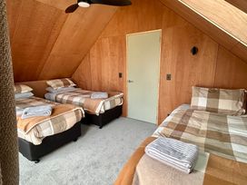 A bedroom with three beds and a door at Cedarwood Retreat - Castle Hill Holiday Home, Castle Hill