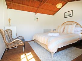 A bedroom with a bed and chair at New Plymouth in New Plymouth