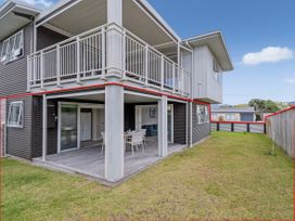 An outdoor patio with a table and chairs at Whangamata Holiday Unit in Whangamata