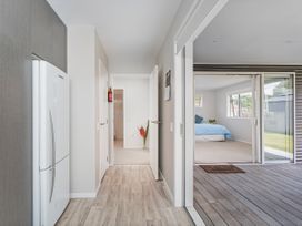 A hallway with a refrigerator and doors at Whangamata Holiday Unit in Whangamata