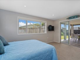 A bedroom with a bed and television at Whangamata Holiday Unit in Whangamata