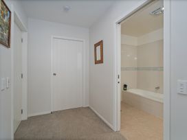A bathroom with a bath tub and a doorway at Whangamata Holiday Unit in Whangamata