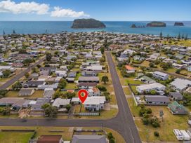 An aerial view of residential area with houses and ocean at Whangamata Holiday Unit in Whangamata