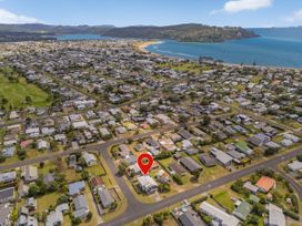 An aerial view of a residential area near the beach at Whangamata Holiday Unit in Whangamata