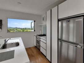 A kitchen with a sink and stove at Mangawhai Holiday Unit in Kaiwaka