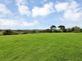 An outdoor area with grass and trees at Mangawhai Holiday Unit in Kaiwaka