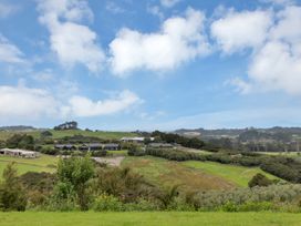 A landscape view with houses and hills at Mangawhai Holiday Unit in Kaiwaka