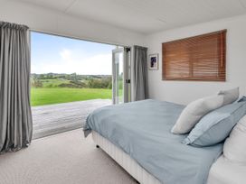A bedroom with a bed and a window at Mangawhai Holiday Unit in Kaiwaka