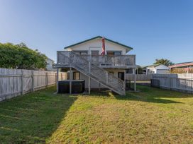 A house with a deck and staircase in the backyard at Pauanui Holiday Home in Pauanui