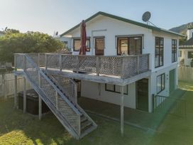 A house with a deck and staircase at Pauanui Holiday Home in Pauanui