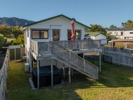A house with a deck and hot tub at Pauanui Holiday Home in Pauanui