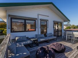 A deck with outdoor seating and a coffee table at Pauanui Holiday Home in Pauanui