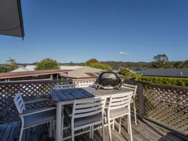 An outdoor space with a table and chairs and a barbecue grill at Pauanui Holiday Home in Pauanui