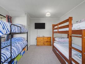 A bedroom with bunk beds and a TV at Pauanui Holiday Home in Pauanui