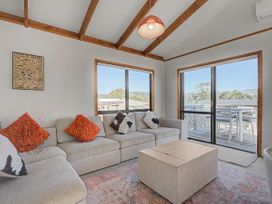 A living room with a sofa and coffee table at Pauanui Holiday Home in Pauanui