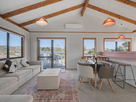A living room with a sofa and dining table at Pauanui Holiday Home in Pauanui