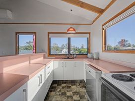 A kitchen with a countertop, sink, and appliances at Pauanui Holiday Home in Pauanui