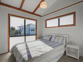 A bedroom with a bed and nightstand at Pauanui Holiday Home in Pauanui