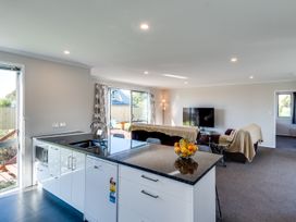 A kitchen and living room area with a dining table at SeaRenity - Waimarama Holiday Home in Havelock North
