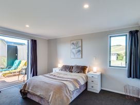 A bedroom with a bed and nightstands at SeaRenity - Waimarama Holiday Home Havelock North