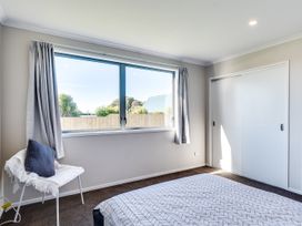 A bedroom with a bed and window at SeaRenity - Waimarama Holiday Home Havelock North