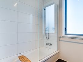 A bathroom with a bathtub and shower at SeaRenity - Waimarama Holiday Home Havelock North