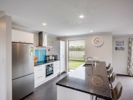 A kitchen with a refrigerator and oven at SeaRenity - Waimarama Holiday Home in Waimarama