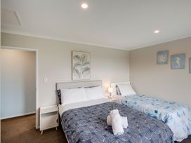 A bedroom with two beds and wall art at SeaRenity - Waimarama Holiday Home Waimarama