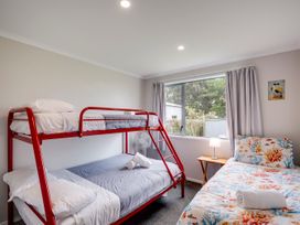 A bedroom with a bunk bed and a single bed at SeaRenity - Waimarama Holiday Home Waimarama