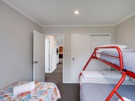 A bedroom with a bunk bed and a single bed at SeaRenity - Waimarama Holiday Home Waimarama