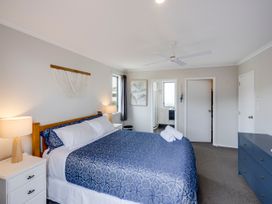 A bedroom with a bed and bedside lamp at SeaRenity - Waimarama Holiday Home, Waimarama