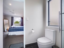 A bathroom with a toilet and a view of a bedroom at SeaRenity - Waimarama Holiday Home Waimarama
