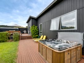 A deck with hot tub and seating area at SeaRenity - Waimarama Holiday Home Waimarama