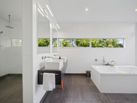 A bathroom with a washbasin and bathtub at Peka Peka Beach House - Waikanae
