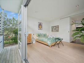 A bedroom with a bed and a nightstand at Peka Peka Beach House - Waikanae