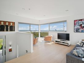 A living room with a sofa and TV at Peka Peka Beach House - Waikanae
