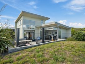 An outdoor view of a house with patio furniture at Peka Peka Beach House - Waikanae