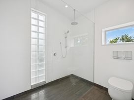 A bathroom with a shower and toilet at Peka Peka Beach House - Waikanae