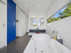 A bathroom with a bathtub and sink at Peka Peka Beach House - Waikanae