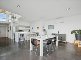 A kitchen with a dining table and chairs at Peka Peka Beach House - Waikanae
