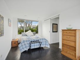 A bedroom with a bed and bedside table at Peka Peka Beach House - Waikanae
