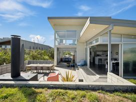 A house with a patio and dining area at Peka Peka Beach House - Waikanae