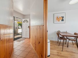 A hallway leading to a dining room with a table and chairs at Hawksie Place in Repoloa